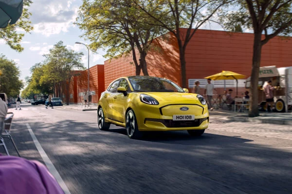 Mise au point sélective sur le capteur de stationnement du pare-chocs arrière près du tuyau d'échappement à l'arrière du pare-chocs de voiture de luxe en gros plan près d'une autre voiture sur fond flou clair avec un fond solaire avec espace de copie