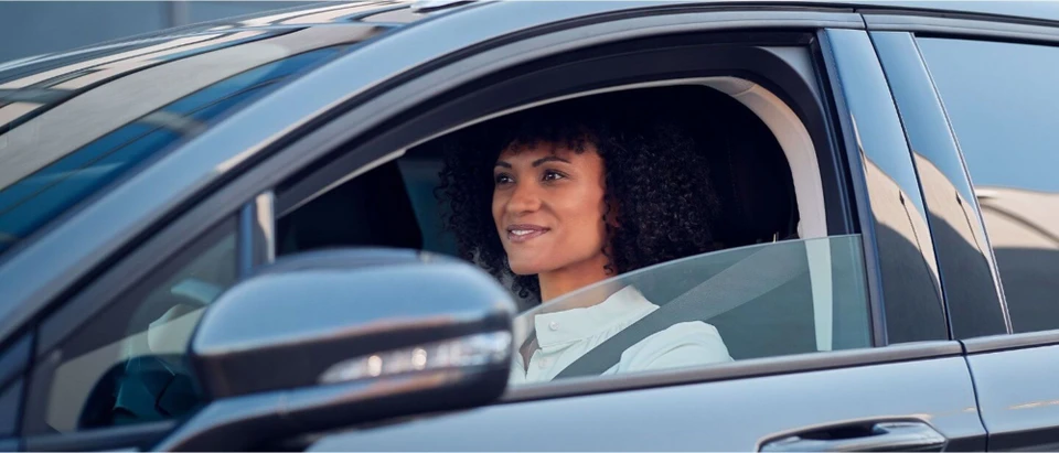 Deux personnes en costume &eacute;changent des cl&eacute;s de voiture &agrave; l'ext&eacute;rieur, l'une tendant les cl&eacute;s &agrave; l'autre dans un geste de remise officielle